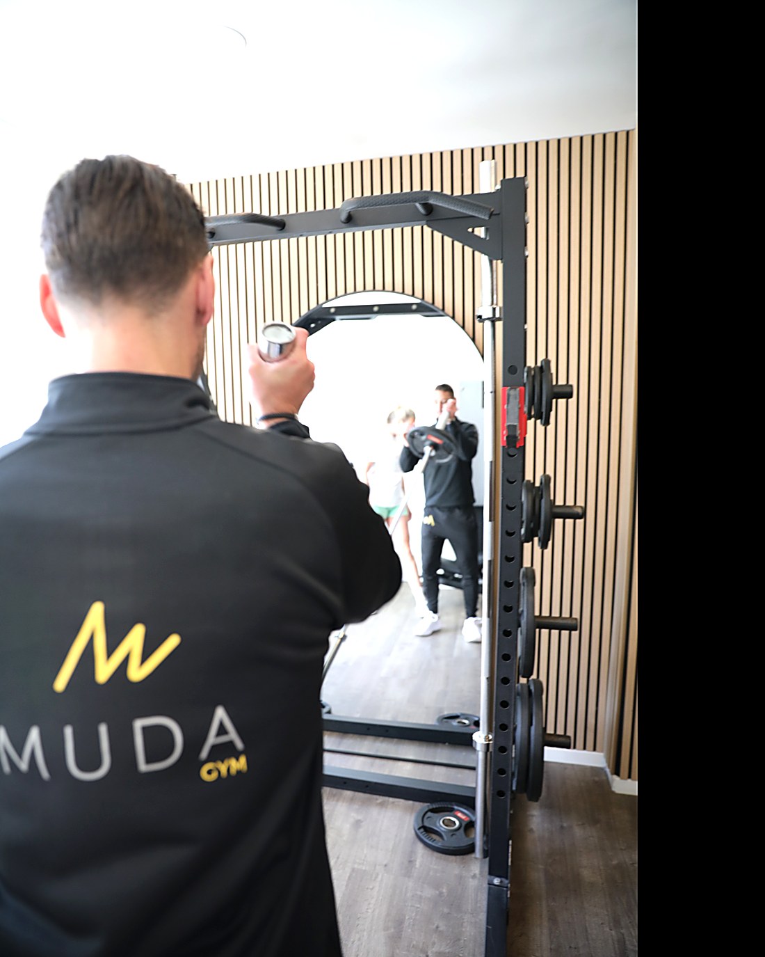 A MudaGym coach working hands-on with a client